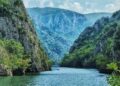 "Kayaking in the serene waters of Matka Canyon with towering cliffs in the background."