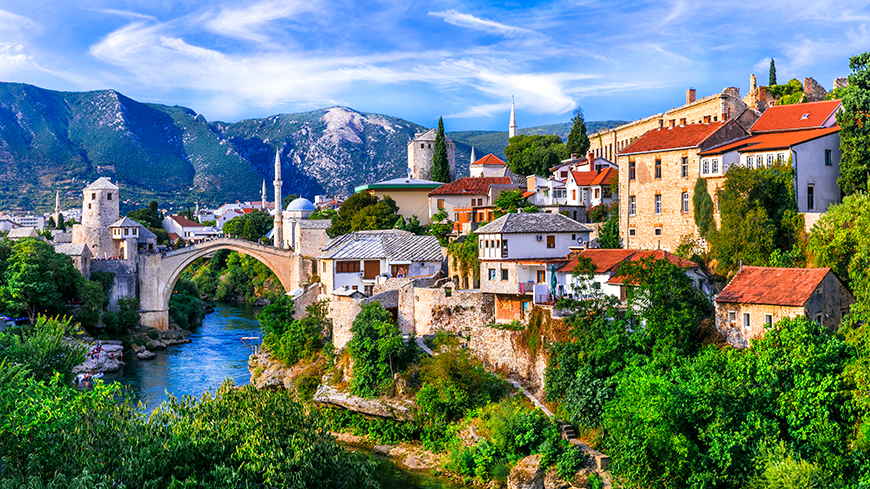 "A stunning view of Bosnia and Herzegovina's landscapes, featuring rolling hills, lush forests, and snow-capped mountains in the distance."