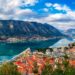 The Bay of Kotor in Montenegro at sunset, a UNESCO World Heritage Site, showcases dramatic mountains, tranquil waters, and historic towns bathed in golden light.