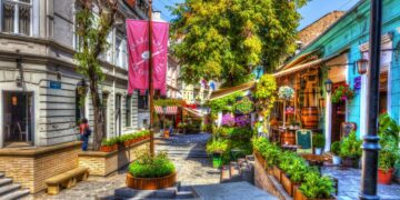 Cobblestone street lined with colorful buildings in Skadarlija, Belgrade at night.