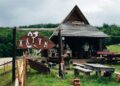 "Traditional stone houses and lush meadows at Etno Katun Durmitor, set against the backdrop of the majestic Durmitor mountains."