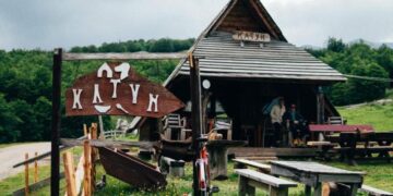 "Traditional stone houses and lush meadows at Etno Katun Durmitor, set against the backdrop of the majestic Durmitor mountains."