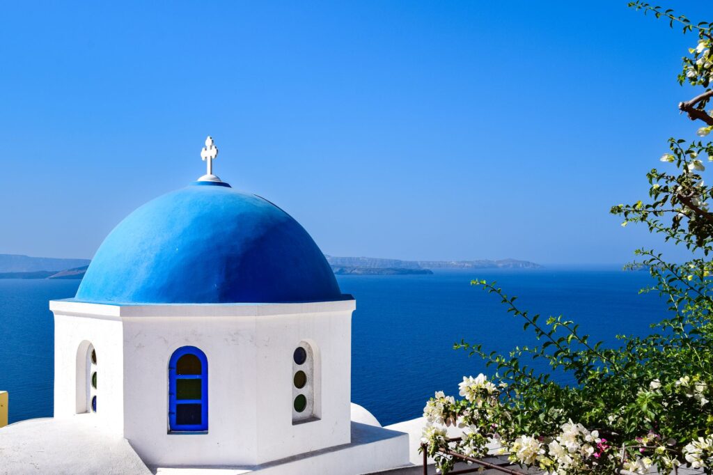 Aegean Islands, Greece — Stunning view of a blue domed church overlooking the Aegean Sea in Santorini, Greece.