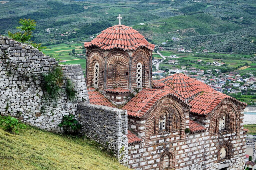 Berat, Albania — Explore the historic Byzantine church at Berat Castle with stunning terracotta tiles and mountain views.