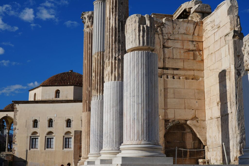 Corinth, Greece — Explore the ancient architectural wonders in Athens, showcasing historical columns against a bright blue sky.