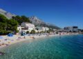 Dalmatia, Croatia — A sunny day at Baška Voda beach, Croatia, with mountains and clear waters.