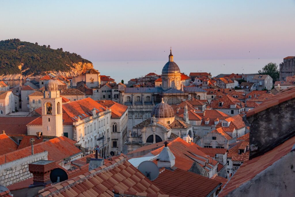 Dubrovnik, Croatia — Captivating sunset over Dubrovnik's Old Town, showcasing iconic terracotta rooftops and historic architecture.