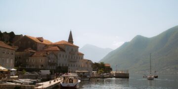 Kotor, Montenegro — Charming view of Perast harbor with boats and historic buildings against mountainous backdrop.