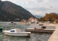 Kotor, Montenegro — Tranquil harbor scene with boats docked by the waterfront, surrounded by picturesque mountains.