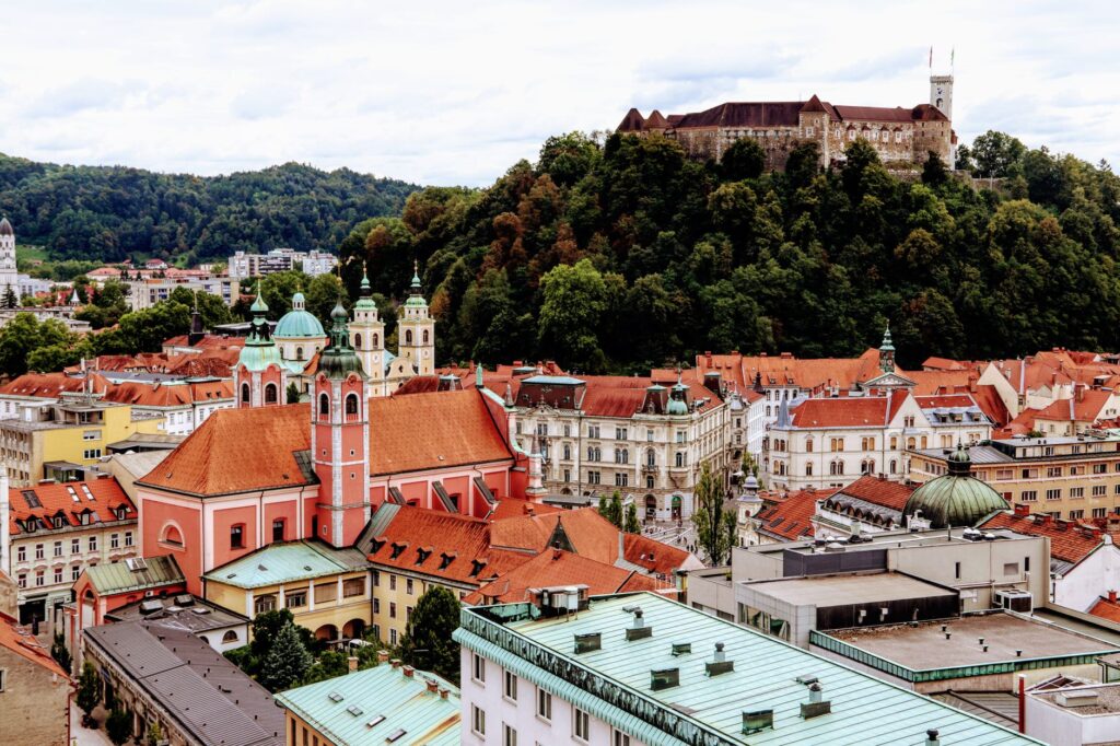 Ljubljana, Slovenia — A scenic view of Ljubljana's vibrant old town with the famous castle atop a green hill.