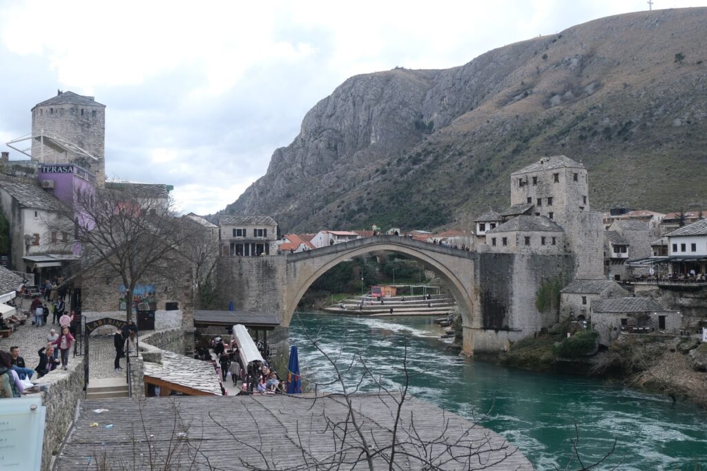 Mostar, Bosnia and Herzegovina — The iconic Stari Most bridge in Mostar spanning the Neretva River, surrounded by mountains.