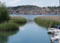 Ohrid, North Macedonia — Panoramic view of Ohrid Lake with lush greenery and a hilltop village in North Macedonia.