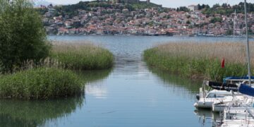 Ohrid, North Macedonia — Panoramic view of Ohrid Lake with lush greenery and a hilltop village in North Macedonia.