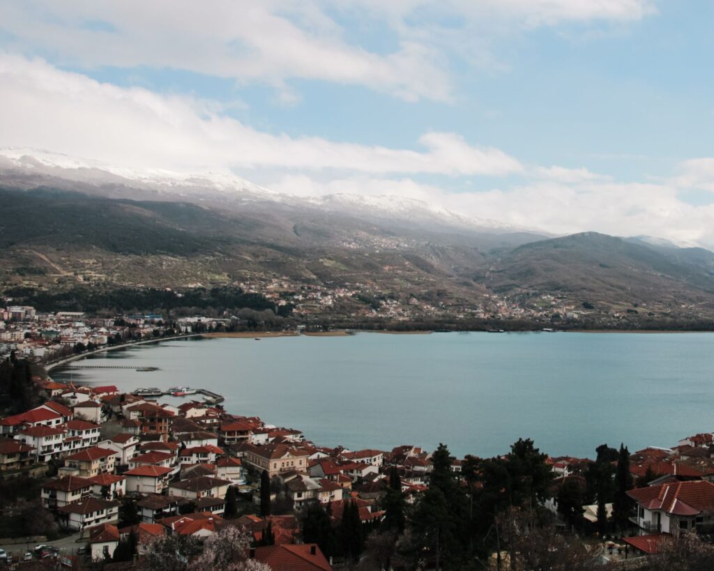 Ohrid, North Macedonia — Aerial view of the picturesque Ohrid Lake with surrounding mountains and red rooftops.