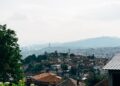 Sarajevo, Bosnia and Herzegovina — Stunning aerial view of Sarajevo with iconic buildings, lush greenery, and distant mountains.