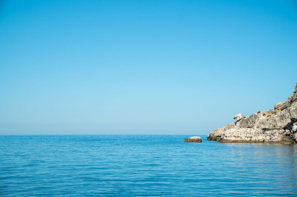 Saranda, Albania — A serene ocean view with clear blue skies and a rocky coastline, ideal for relaxation themes.