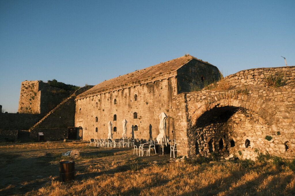 Shkoder, Albania — Historic Shkodër Castle in Albania at sunset with empty outdoor seating.