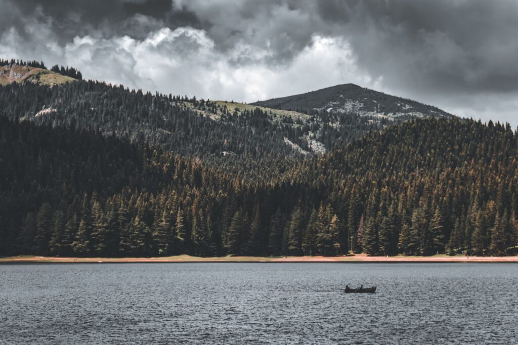 Zabljak, Montenegro — Scenic view of a peaceful lake surrounded by rocky mountains and dense evergreen forests in Montenegro.