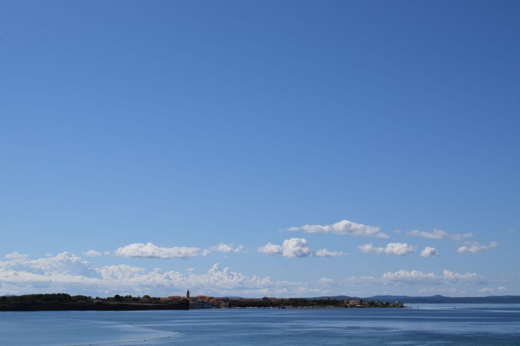 Zadar, Croatia — A serene view of the coastline in Privlaka, Croatia under a clear blue sky.