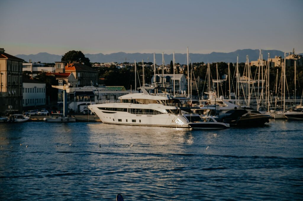 Zadar, Croatia — A luxurious yacht docked at Zadar Port with scenic coastal views and clear blue sky.
