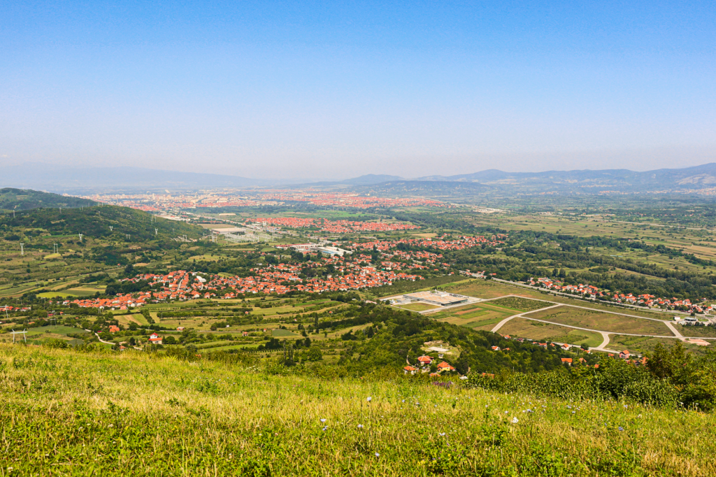 Niš, Serbia — Explore a breathtaking aerial view of the verdant Niš countryside in Serbia, captured under a clear blue sky.