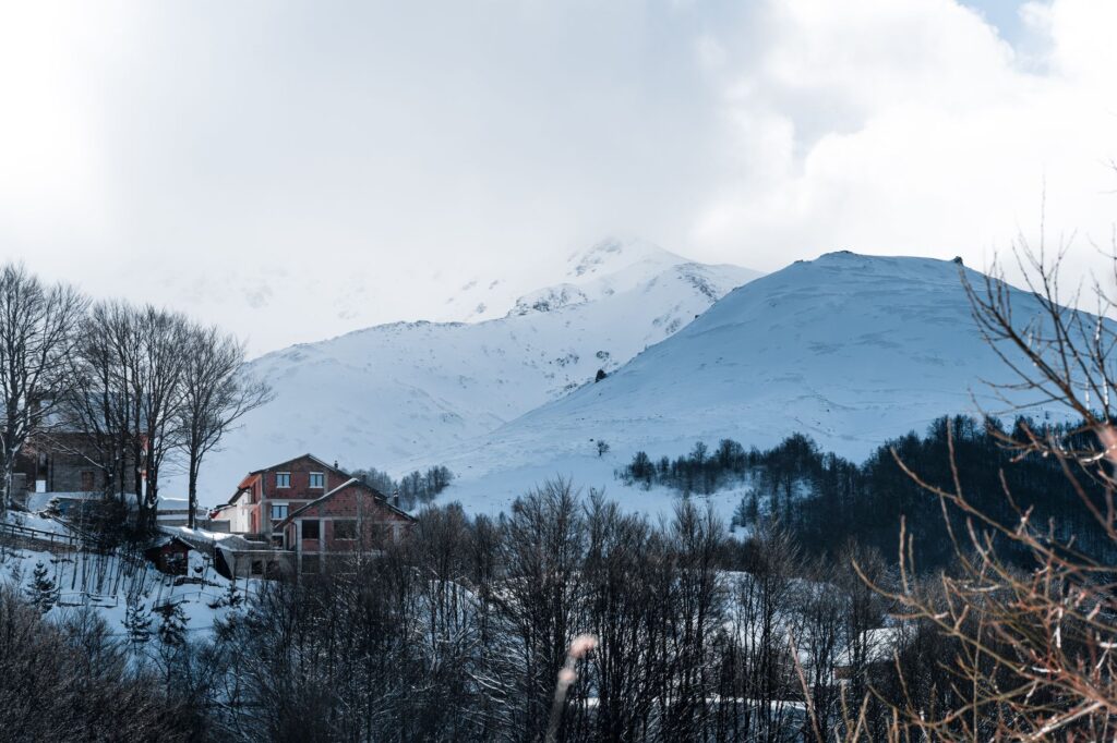 Prizren, Kosovo — Charming winter scene of snow-covered houses and mountains in Prizren, perfect for travel enthusiasts.