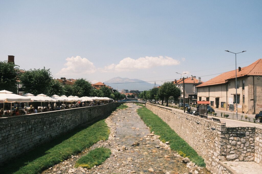 Prizren, Kosovo — Captivating view of Prizren river with cityscape and outdoor cafes in summer