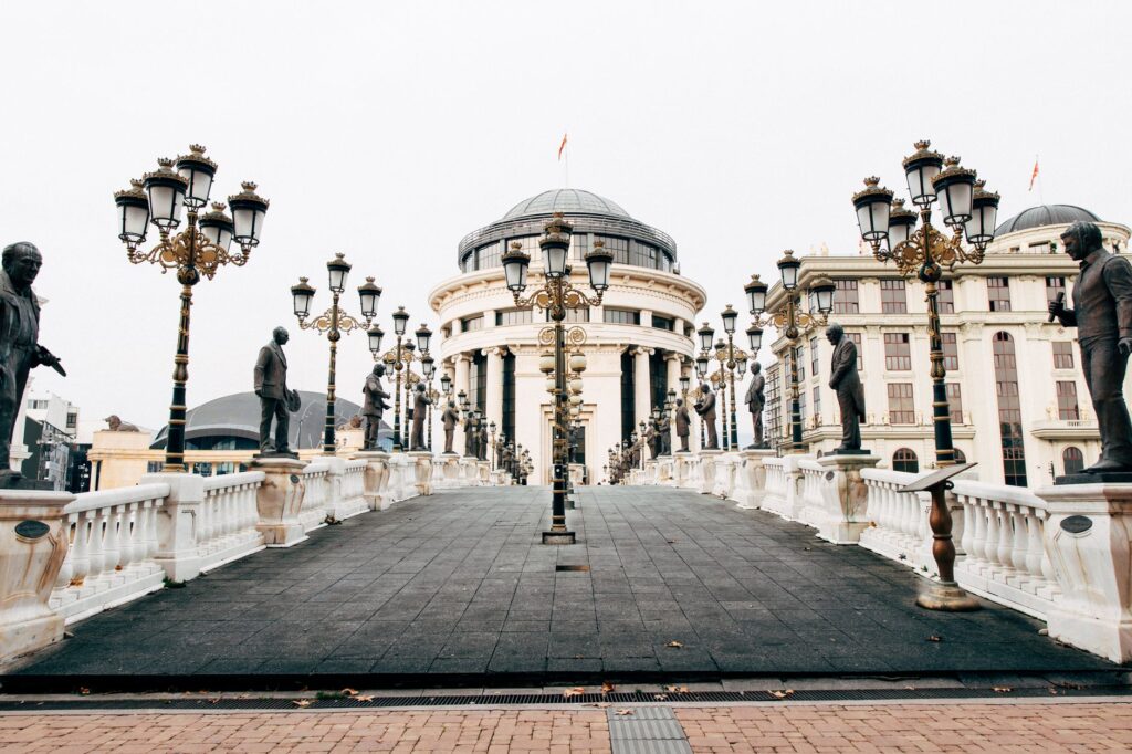 Skopje, North Macedonia — Stunning view of an architectural bridge adorned with sculptures, leading to grand buildings in Skopje.