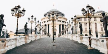 Skopje, North Macedonia — Stunning view of an architectural bridge adorned with sculptures, leading to grand buildings in Skopje.