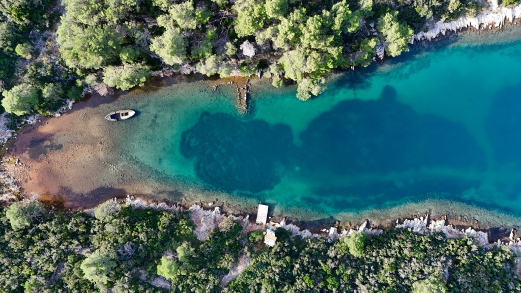 Zadar, Croatia — Stunning aerial view of a turquoise lagoon surrounded by lush greenery in Zadar, Croatia.