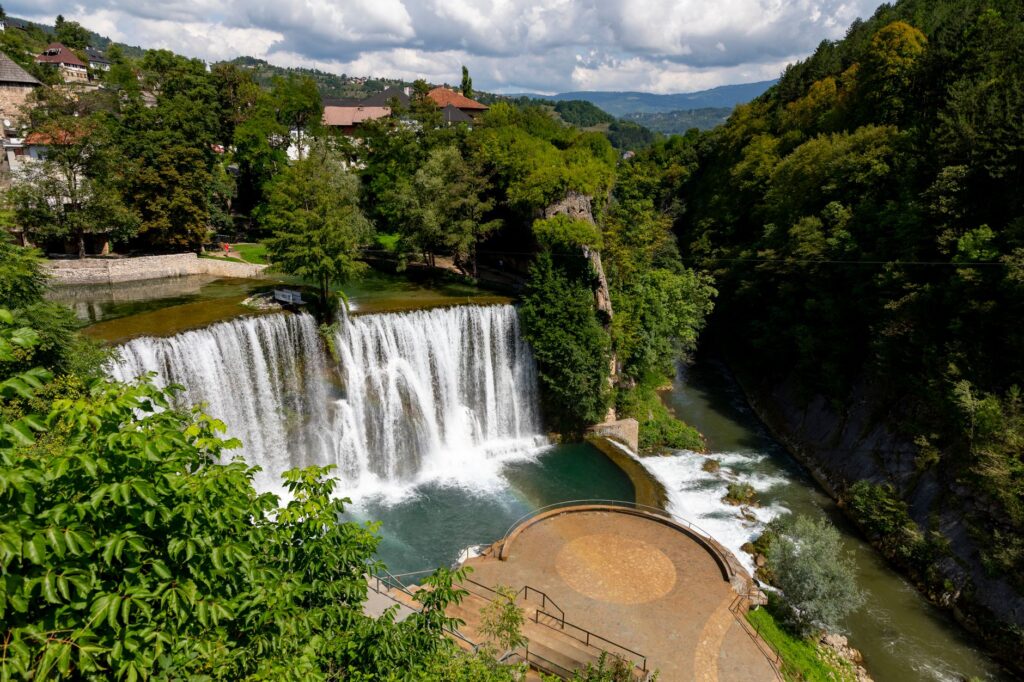 Jajce, Bosnia and Herzegovina — Scenic view of Pliva Waterfall surrounded by lush greenery in Jajce, Bosnia and Herzegovina.