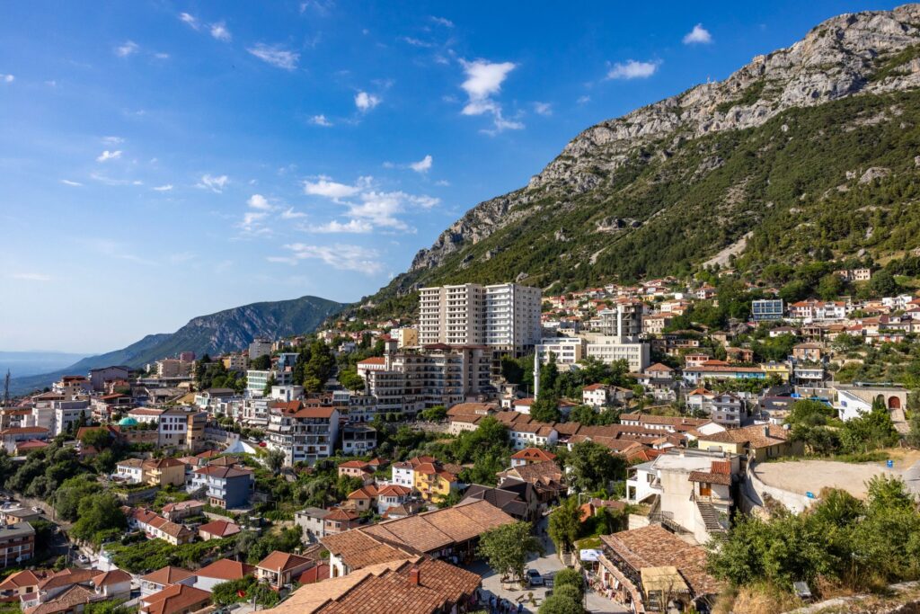 Kruje, Albania — Picturesque view of Krujë city nestled against mountains in Albania under a clear blue sky.