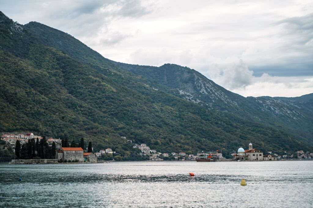 Perast, Montenegro — Picturesque landscape of Perast and the Bay of Kotor in Montenegro, featuring lush mountains and serene waters.