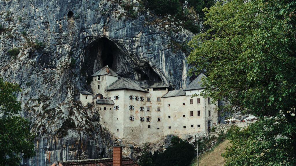 Postojna, Slovenia — Predjama Castle nestled in a cliff near Postojna, Slovenia, showcasing a stunning medieval architecture.