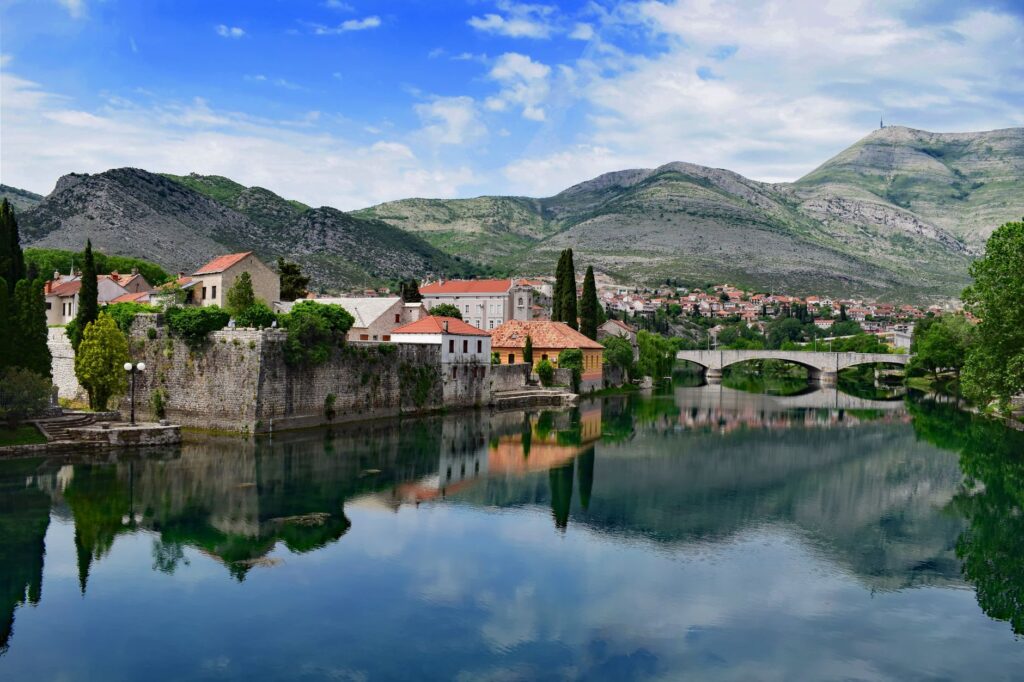 Trebinje, Bosnia and Herzegovina — A serene view of Trebinje with historic architecture, river reflections, and mountain backdrop.